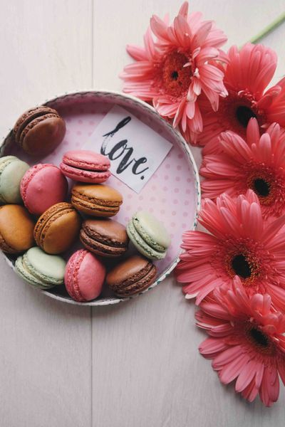 a plate of macaroons with flowers and text saying Love